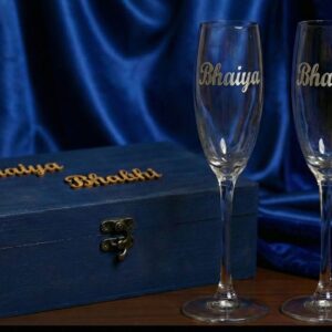 Personalized wine glasses with real silver name detailing placed in front of a custom wooden gift box with matching names